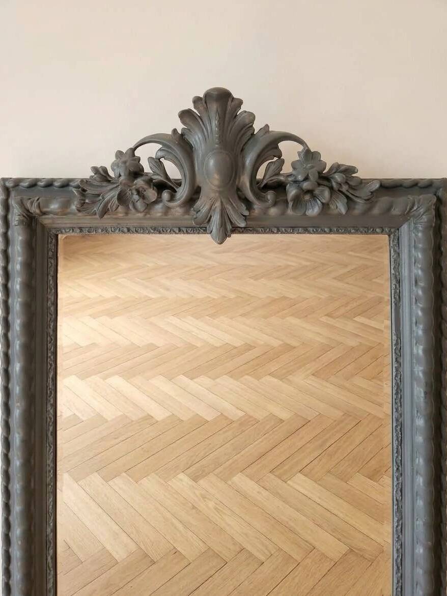Antique mirror with a sculpted pediment in classic grey style.