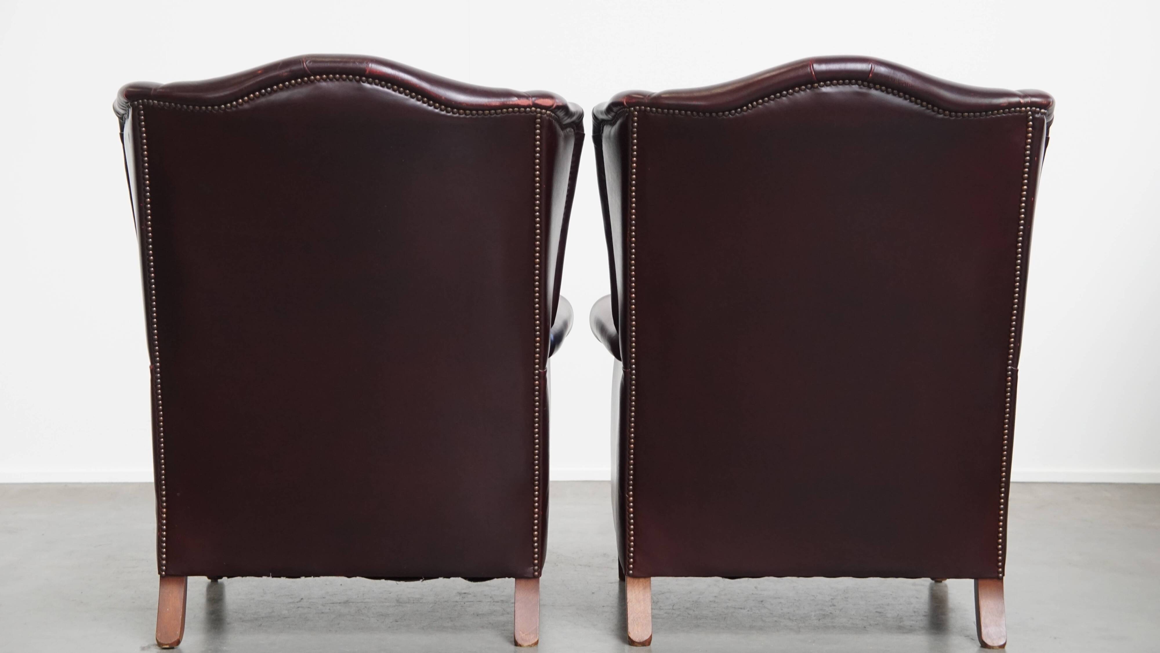 Ensemble de 2 fauteuils à oreilles en cuir de vachette + pouf de style anglais
