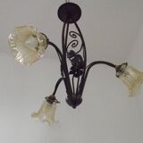 French Art Nouveau leaf detail iron three-light chandelier with amber glass shades.