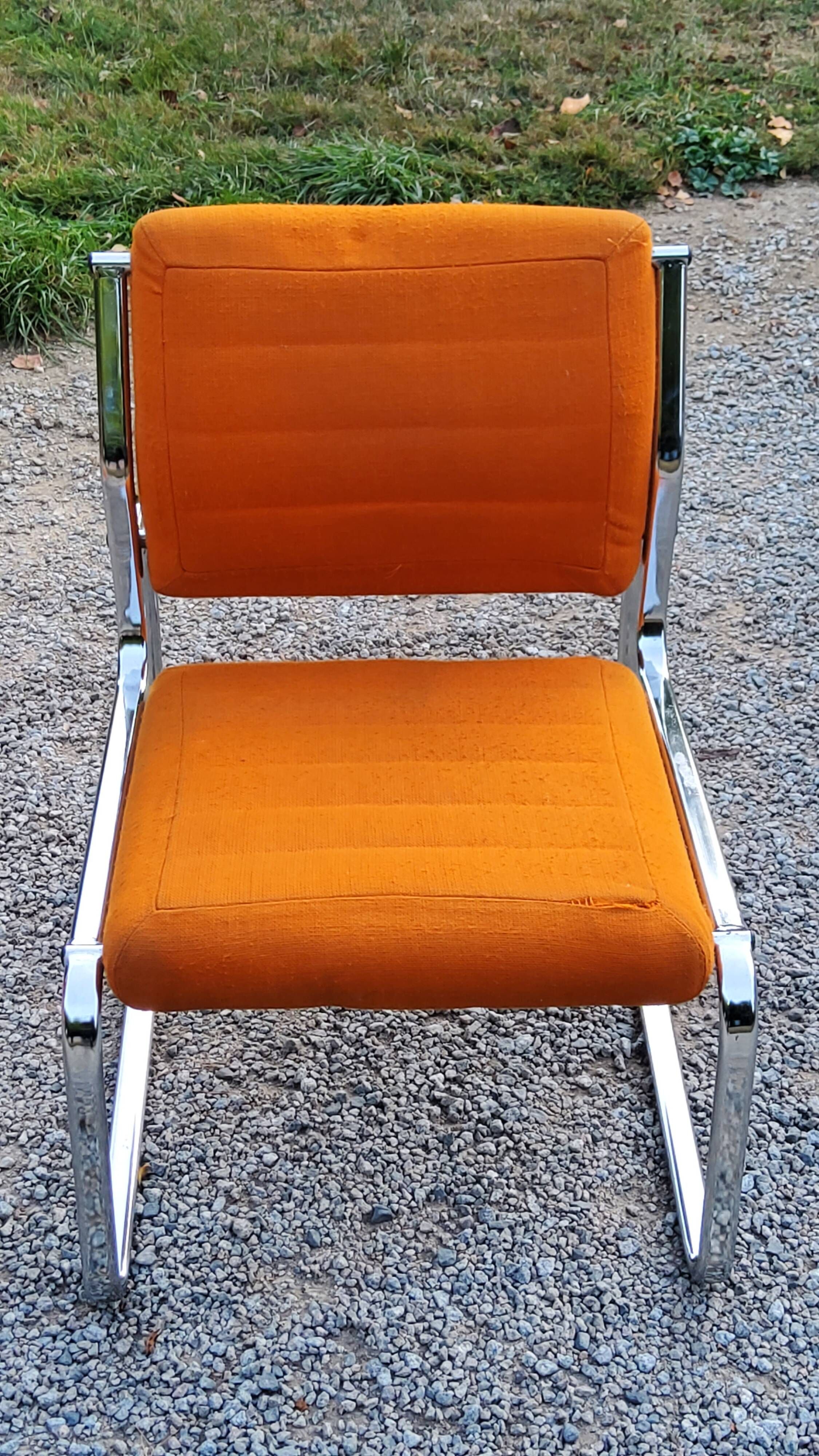 Pair of designer armchairs in orange fabrics and chrome tubes from the 70s