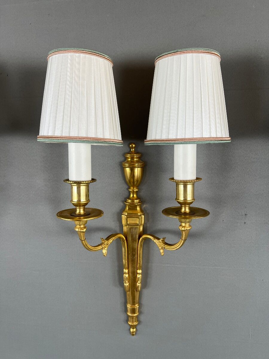 Set of three Louis XVI style wall sconces in gilded bronze, 20th century.