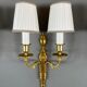Set of three Louis XVI style wall sconces in gilded bronze, 20th century.