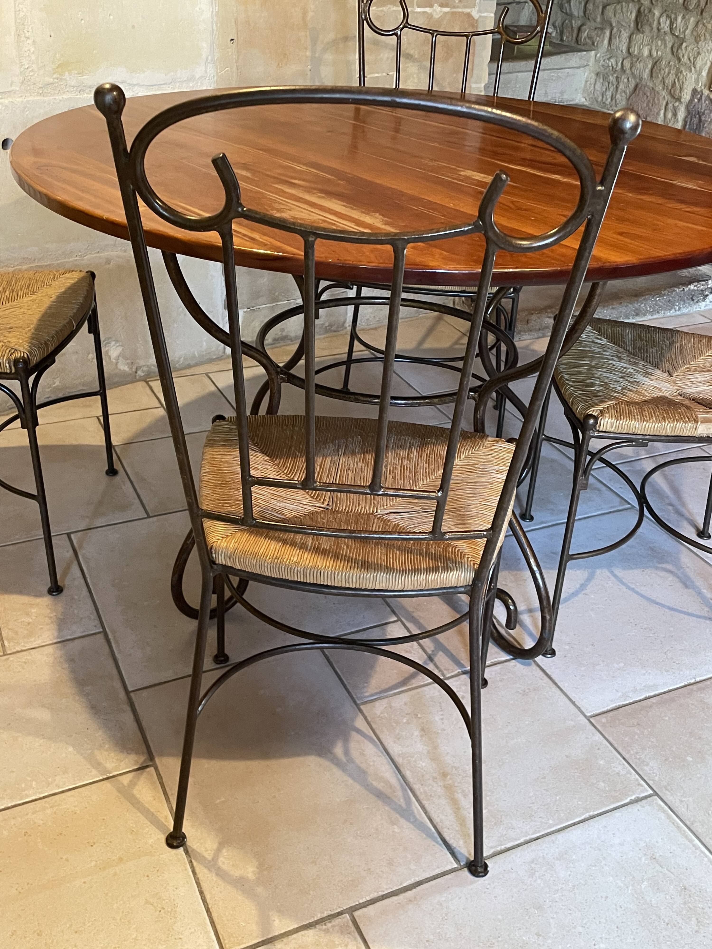Table and four wrought iron and wood chairs.