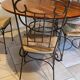 Table and four wrought iron and wood chairs.