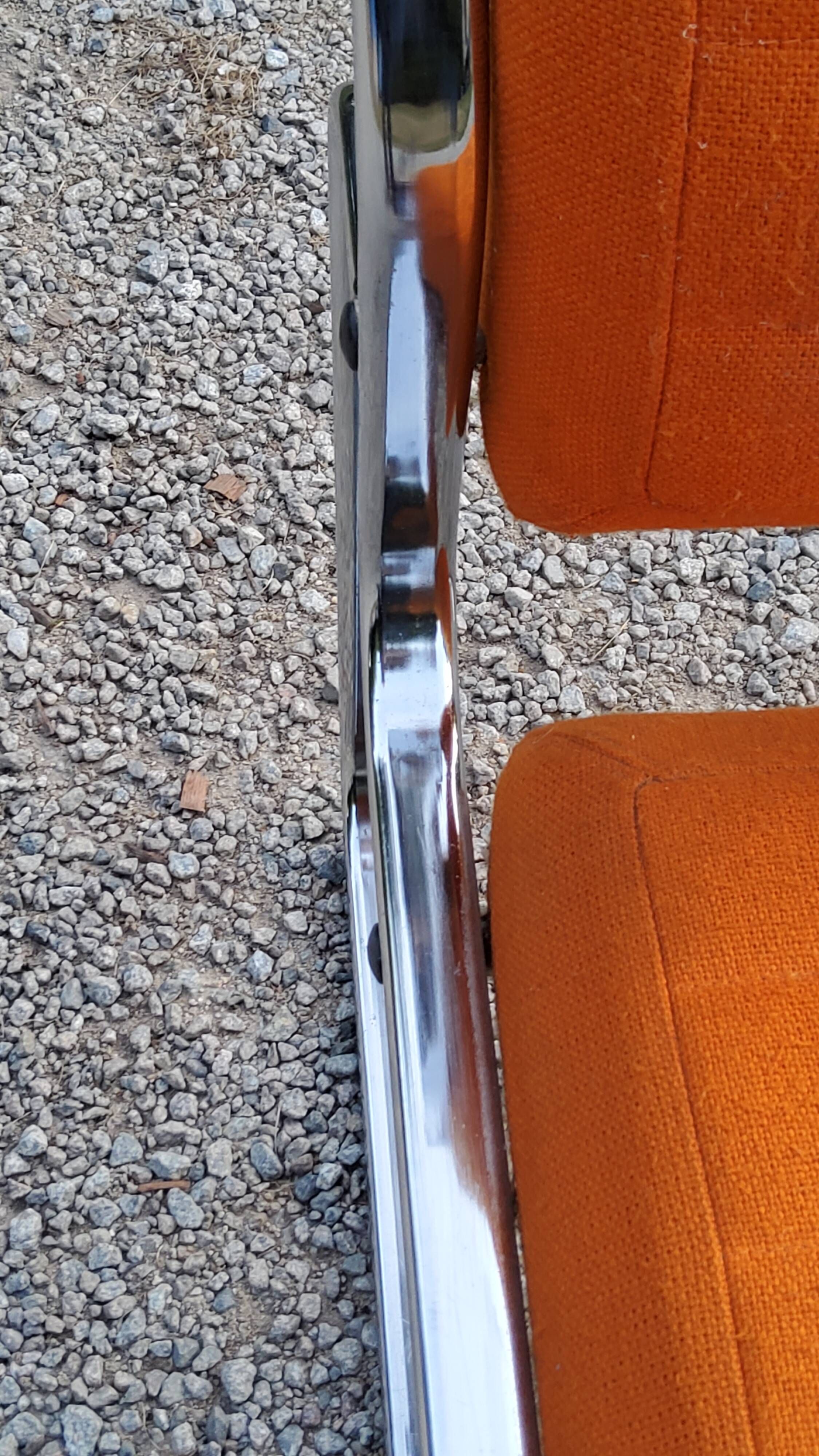 Pair of designer armchairs in orange fabrics and chrome tubes from the 70s