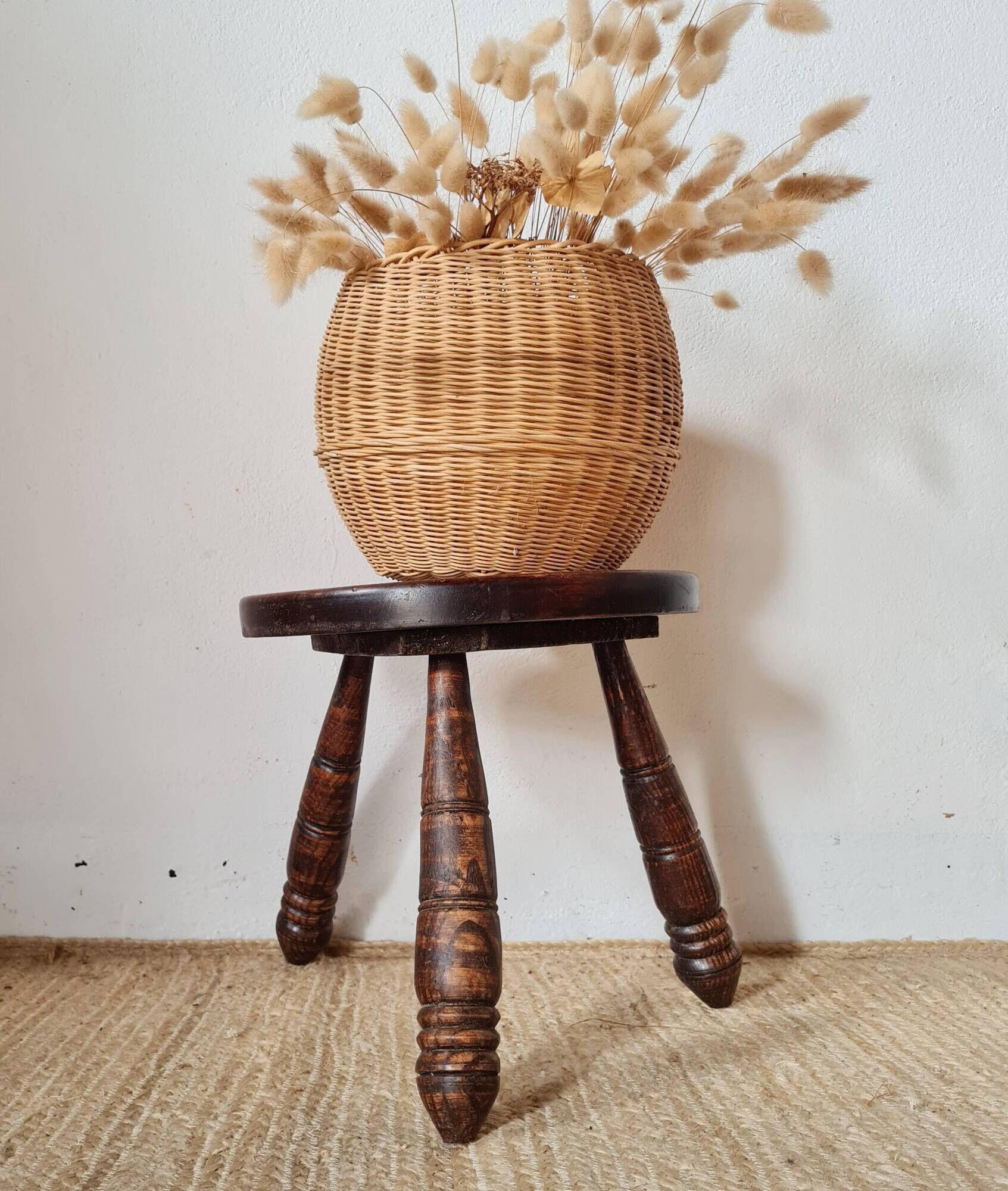 Small brutalist tripod stool made of turned wood.