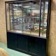 Store window with sliding doors in matte black patinated oak - 30s