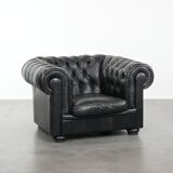 Comfortable black chesterfield armchair made of cowhide leather