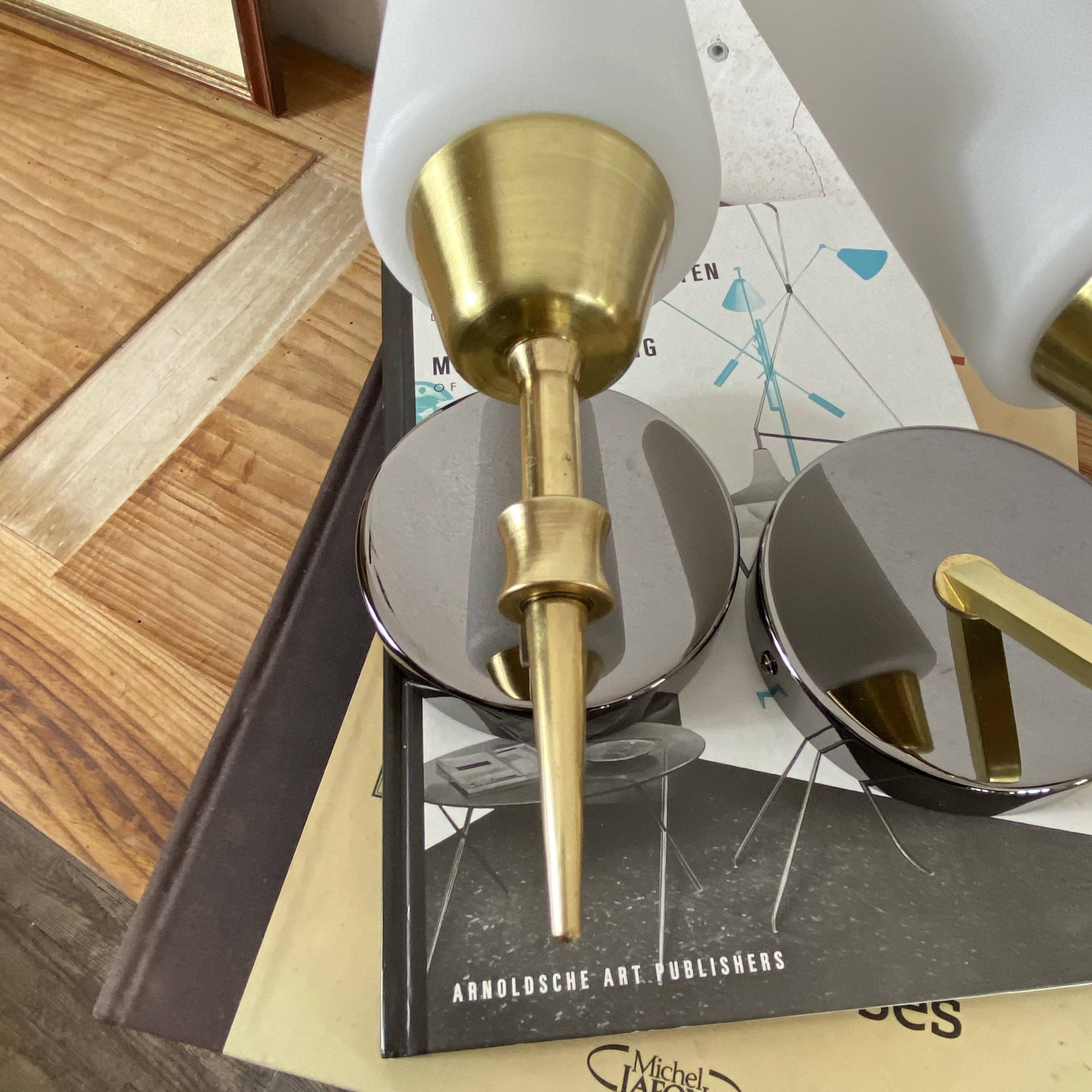 Pair of wall sconces in brass with white glass tulips.