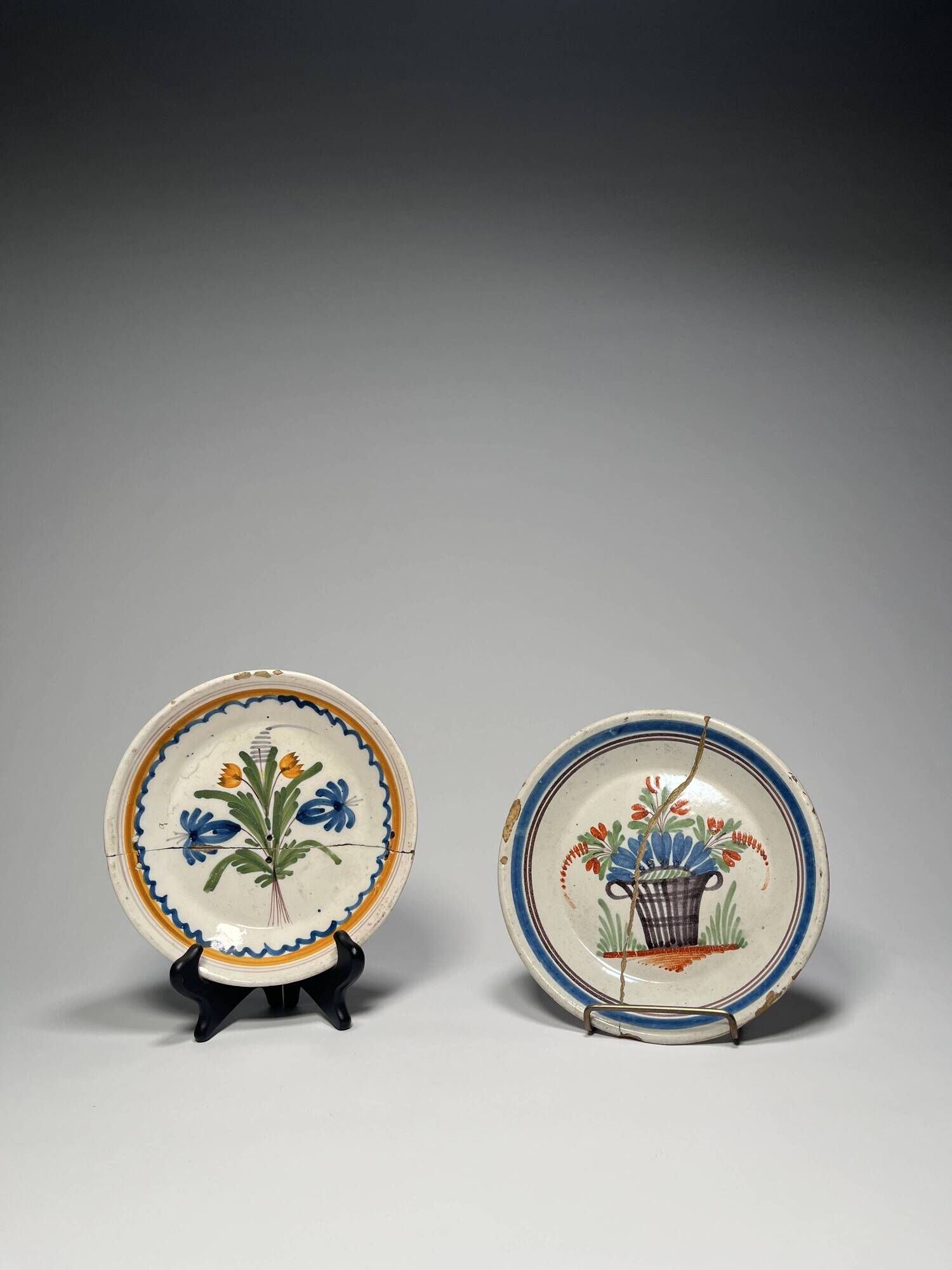 Two antique 18th-century faience plates, stapled.