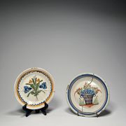 Two antique 18th-century faience plates, stapled.
