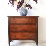 Antique oak chest of drawers on castors with brass handles and carved details