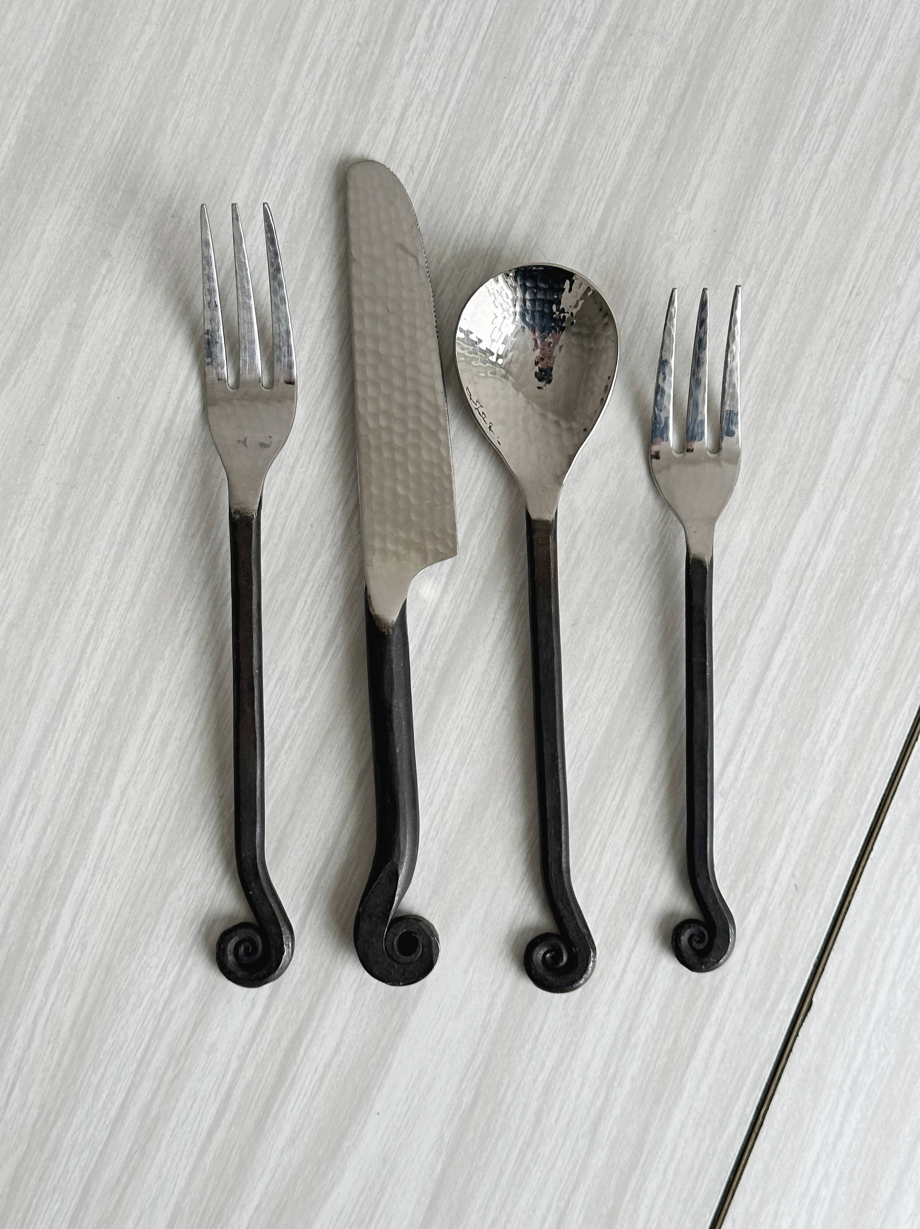 Set of 4 hammered metal cutlery with snail pattern.
