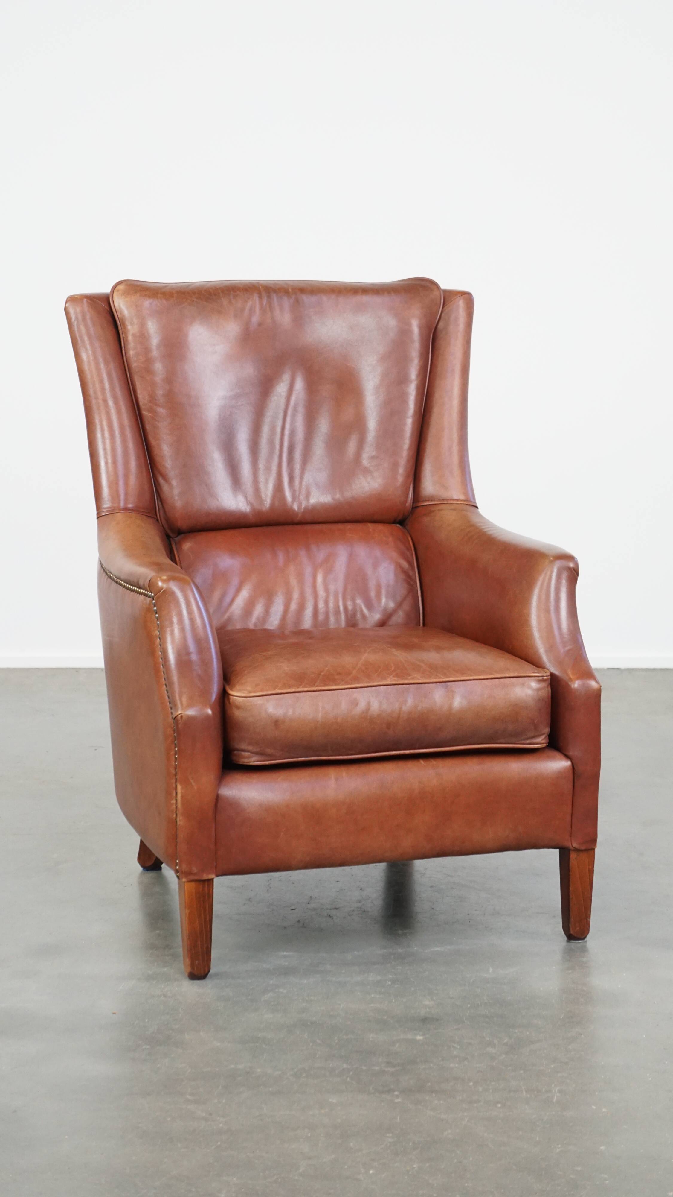 Cowhide armchair in good condition, finished with decorative nails