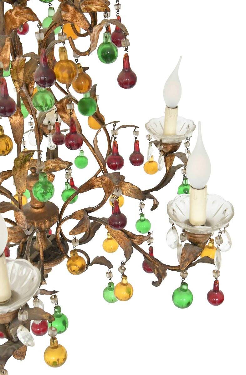 Lustrous chandelier with two wall lights decorated with foliage and pendants.