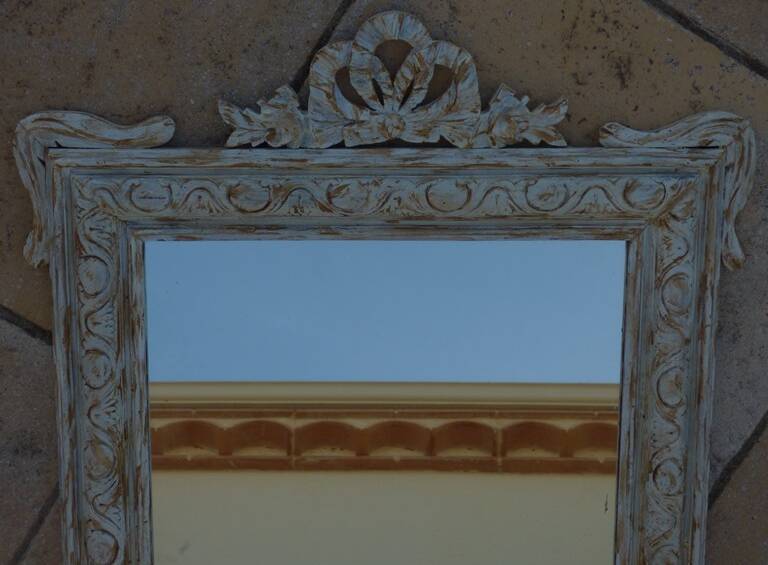 Chic and stylish old mirror with carved wooden frame in limed white and gold