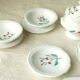 Tableware set in earthenware with floral decoration.