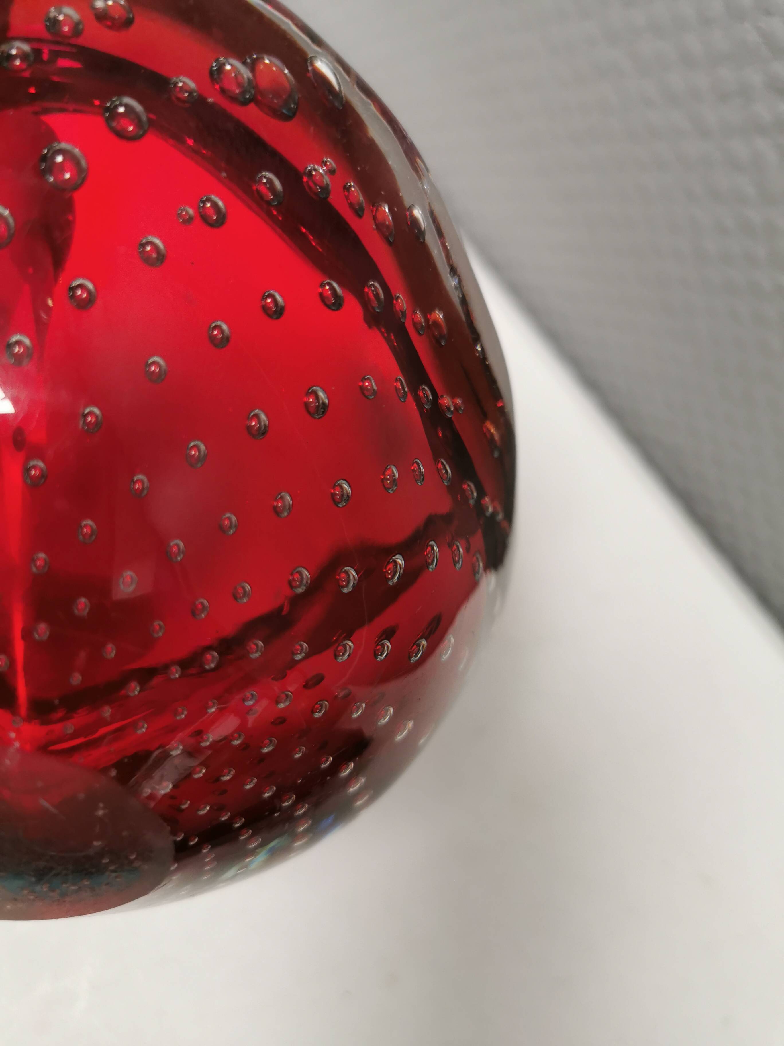 Small glass bowl in beautiful emerald red color with inlaid bubbles.