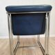 Fauteuil lounge vintage en cuir bleu marine : structure tubulaire chromée, style italien futuriste.