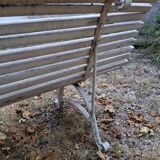 Pair of antique wooden slatted benches with wrought iron legs.
