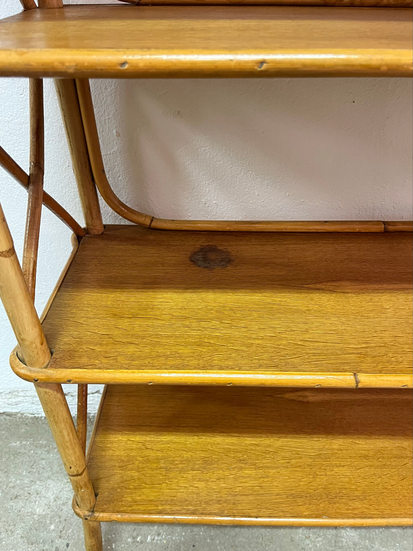 Vintage shelf on legs made of rattan and wood.