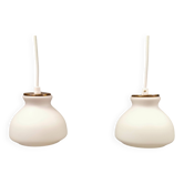 Une paire de lampes suspendues de la verrerie danoise Holmegaard avec abat-jour en verre blanc laiteux.