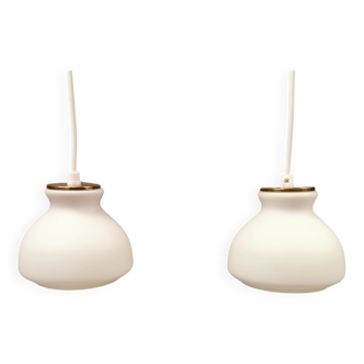 A pair of hanging lamps from Danish Holmegaard glassworks with milky white glass shade.