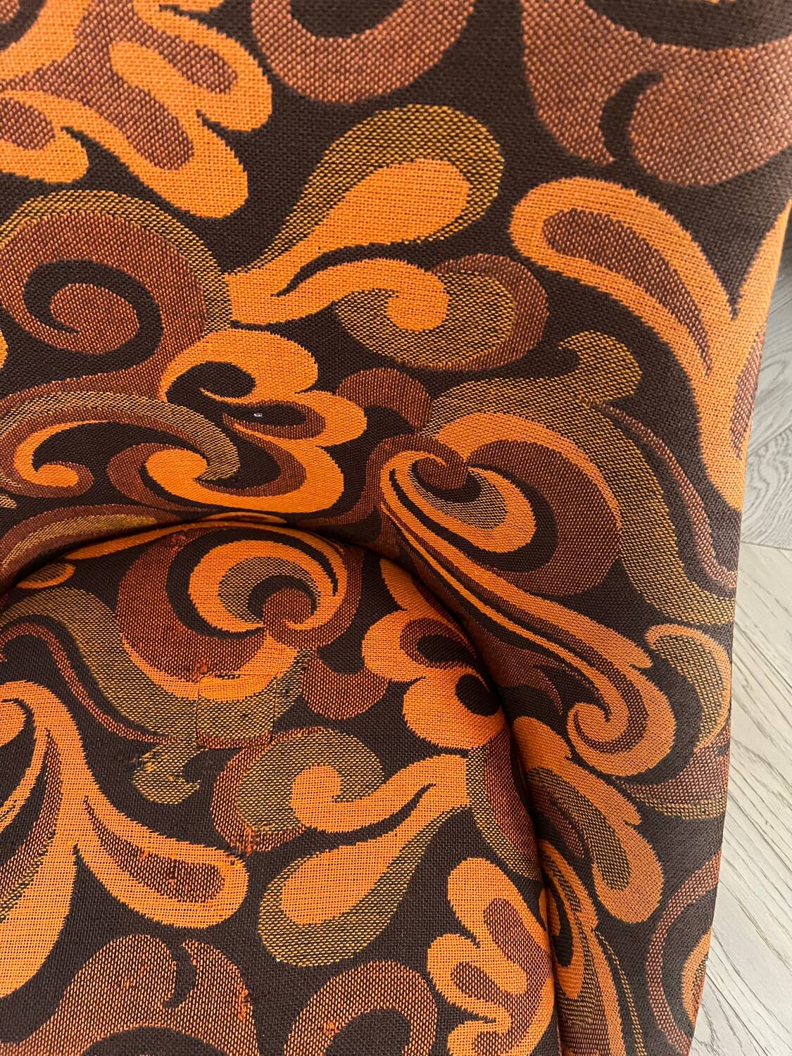 Vintage space age swivel chair with psychedelic pattern in shades of orange.