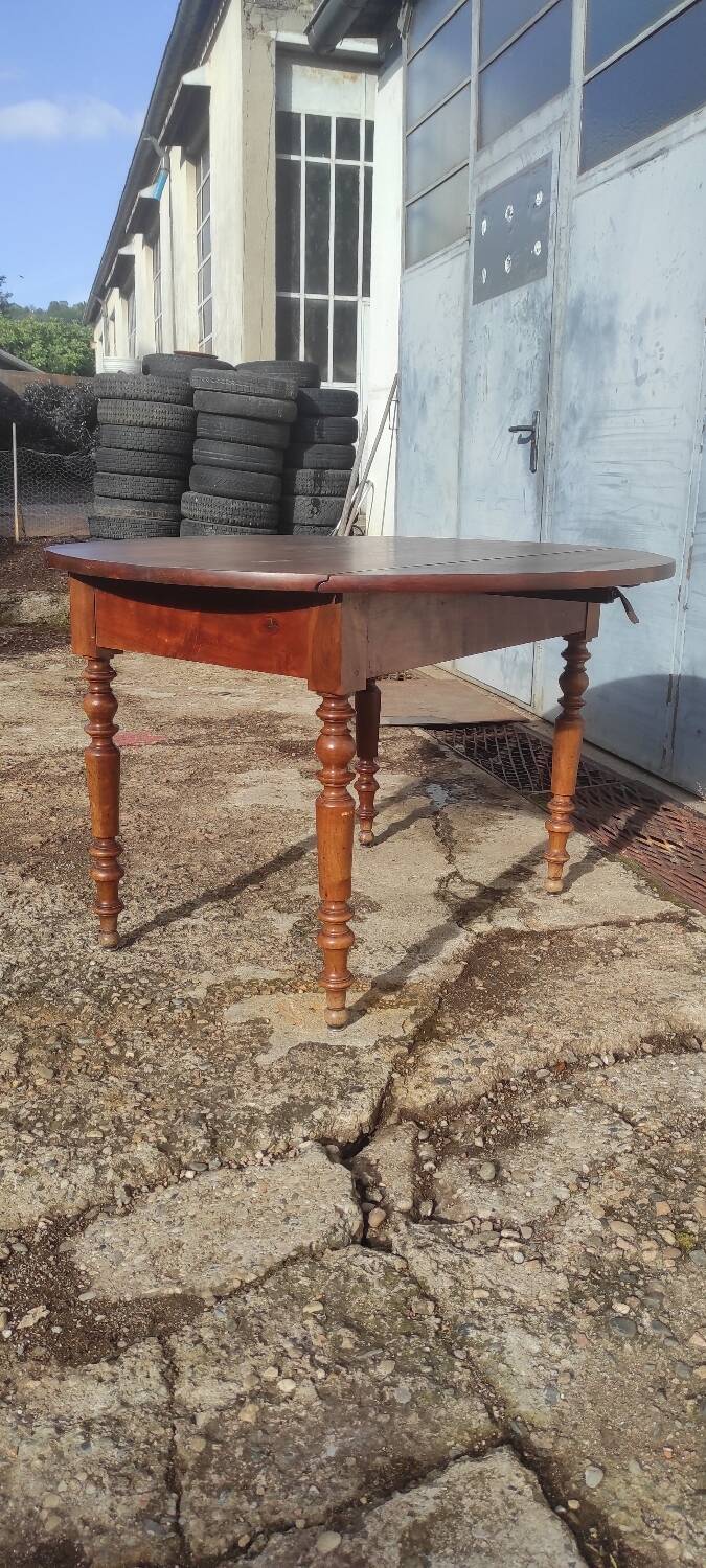 Old extendable round table in fruit wood with folding sides