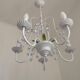 Chandelier vintage en métal blanc à 5 lumières avec des fleurs de glycine roses.