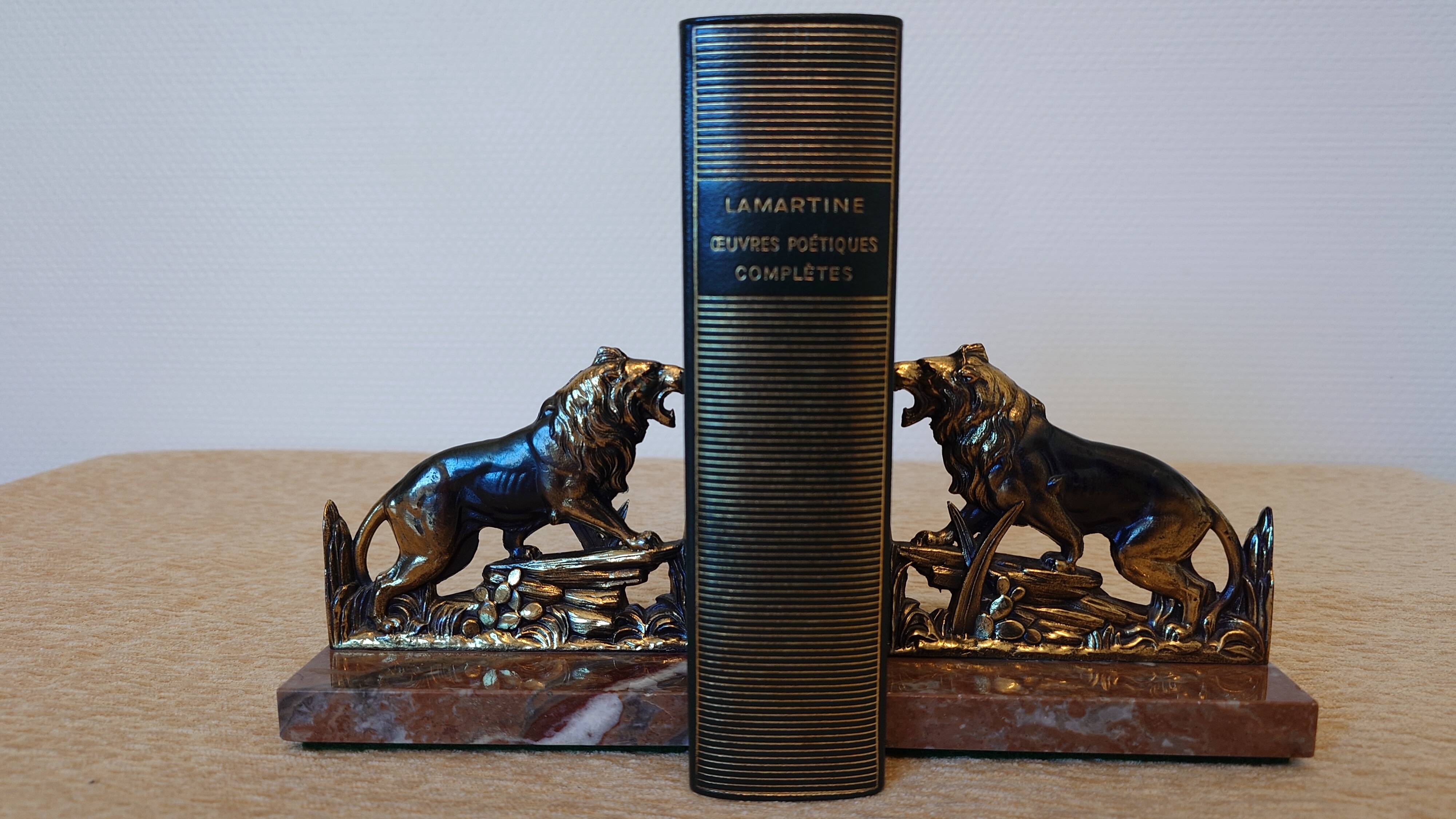 Small roaring lion bookends in patinated metal on a marble base.