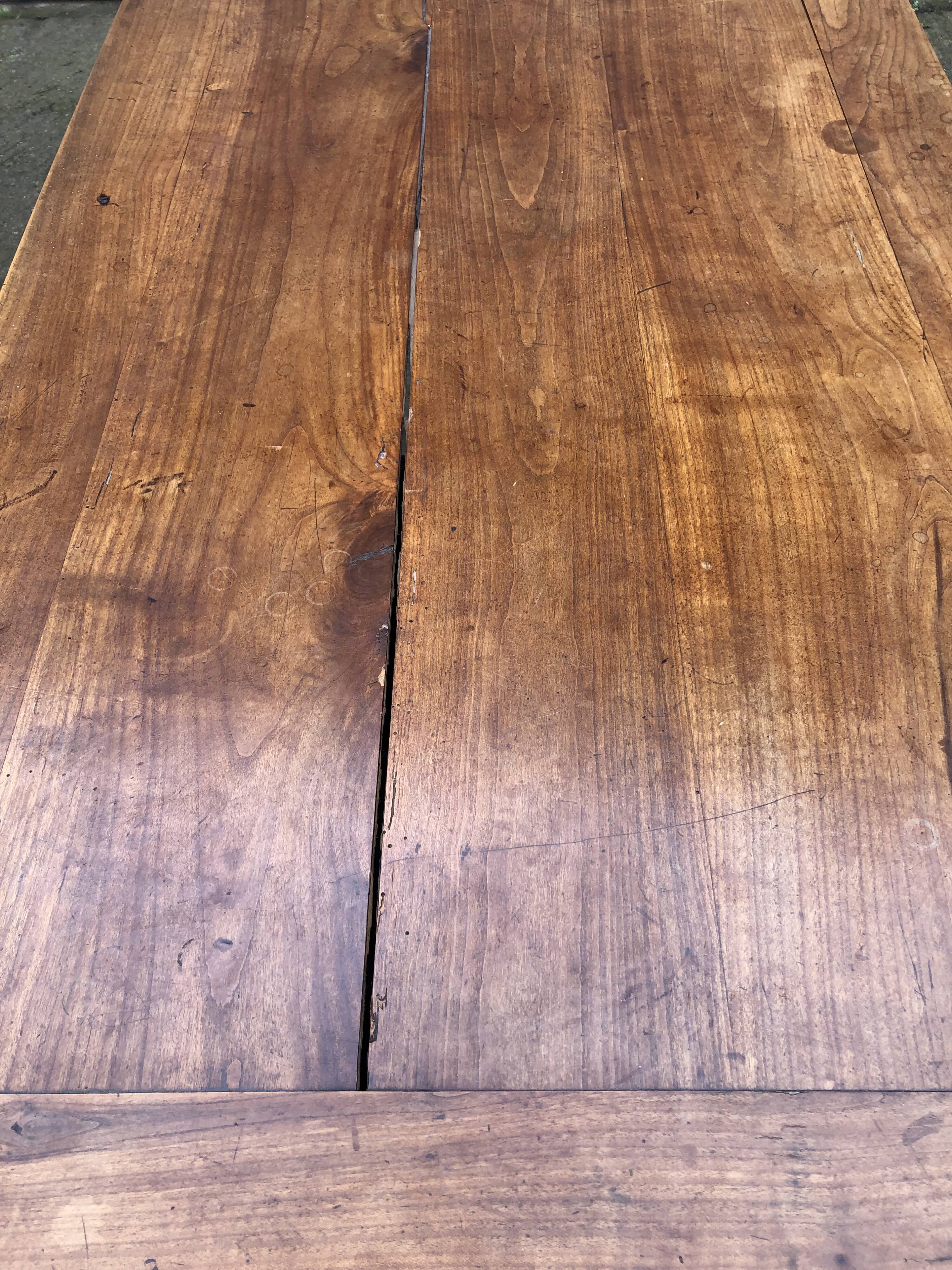 Antique solid cherry farmhouse table with 2 end drawers and 1 pull-out.