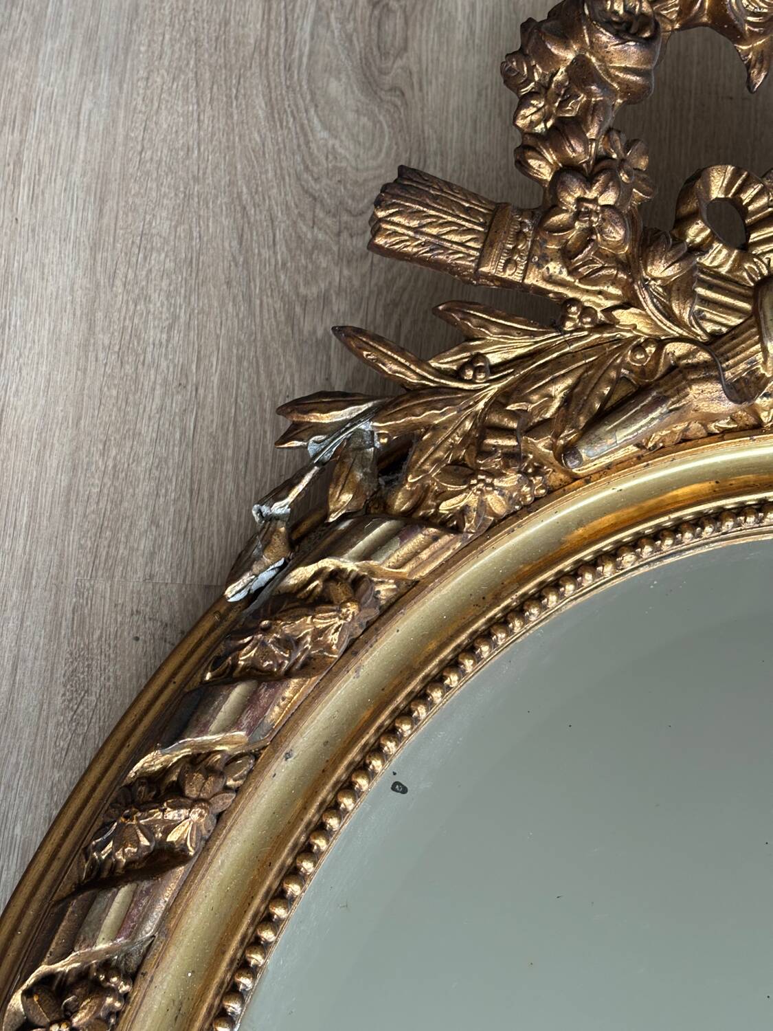 19th century oval gilded mirror, torch & quiver 106cm