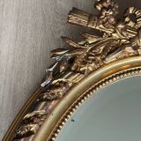 19th century oval gilded mirror, torch & quiver 106cm