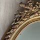 19th century oval gilded mirror, torch & quiver 106cm