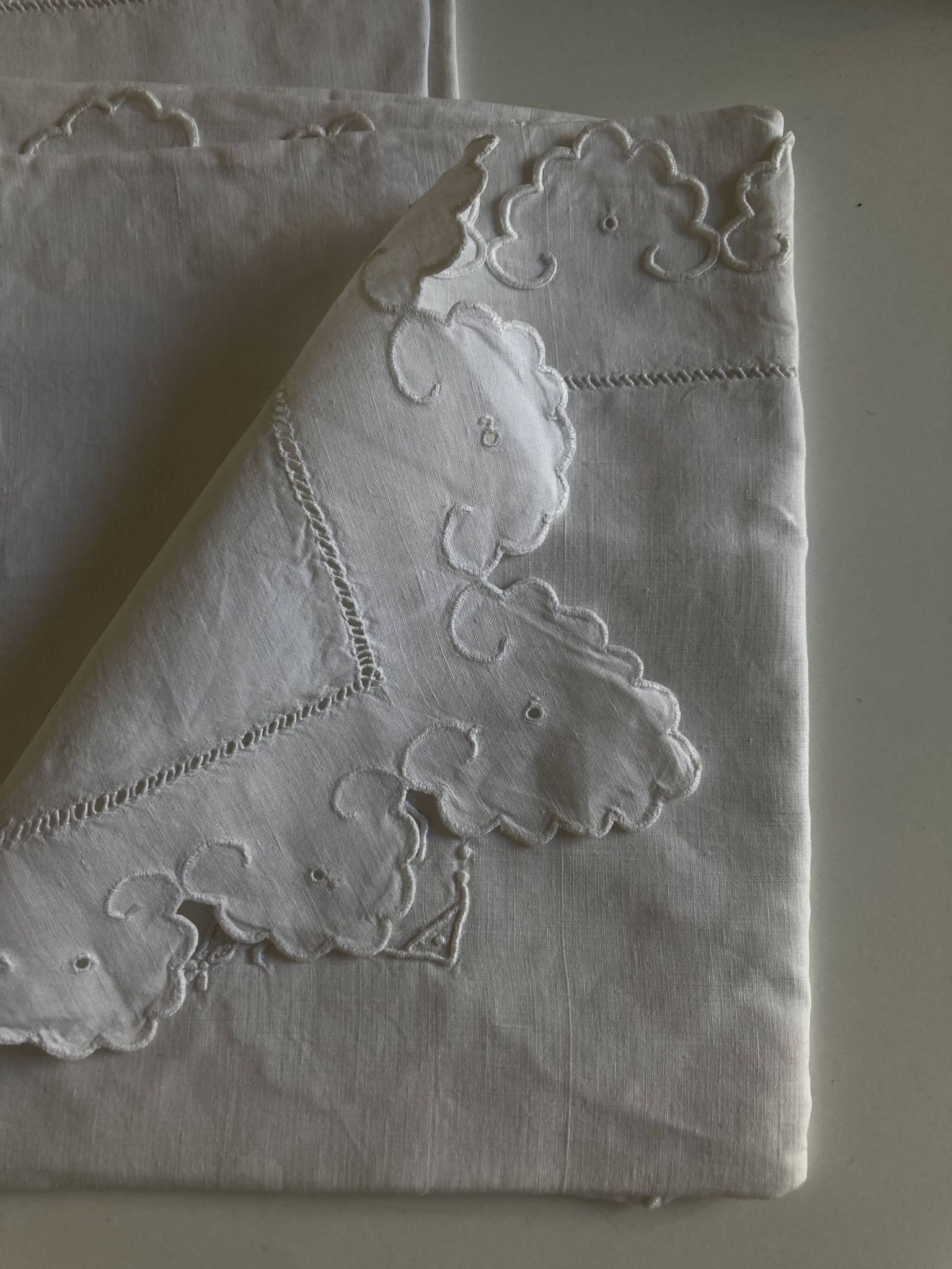 Pair of 19th-century linen pillowcases embroidered with scallops.