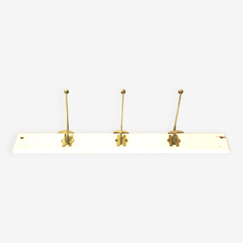 Old wall-mounted coat rack in wood and brass.