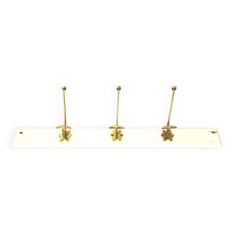 Old wall-mounted coat rack in wood and brass.