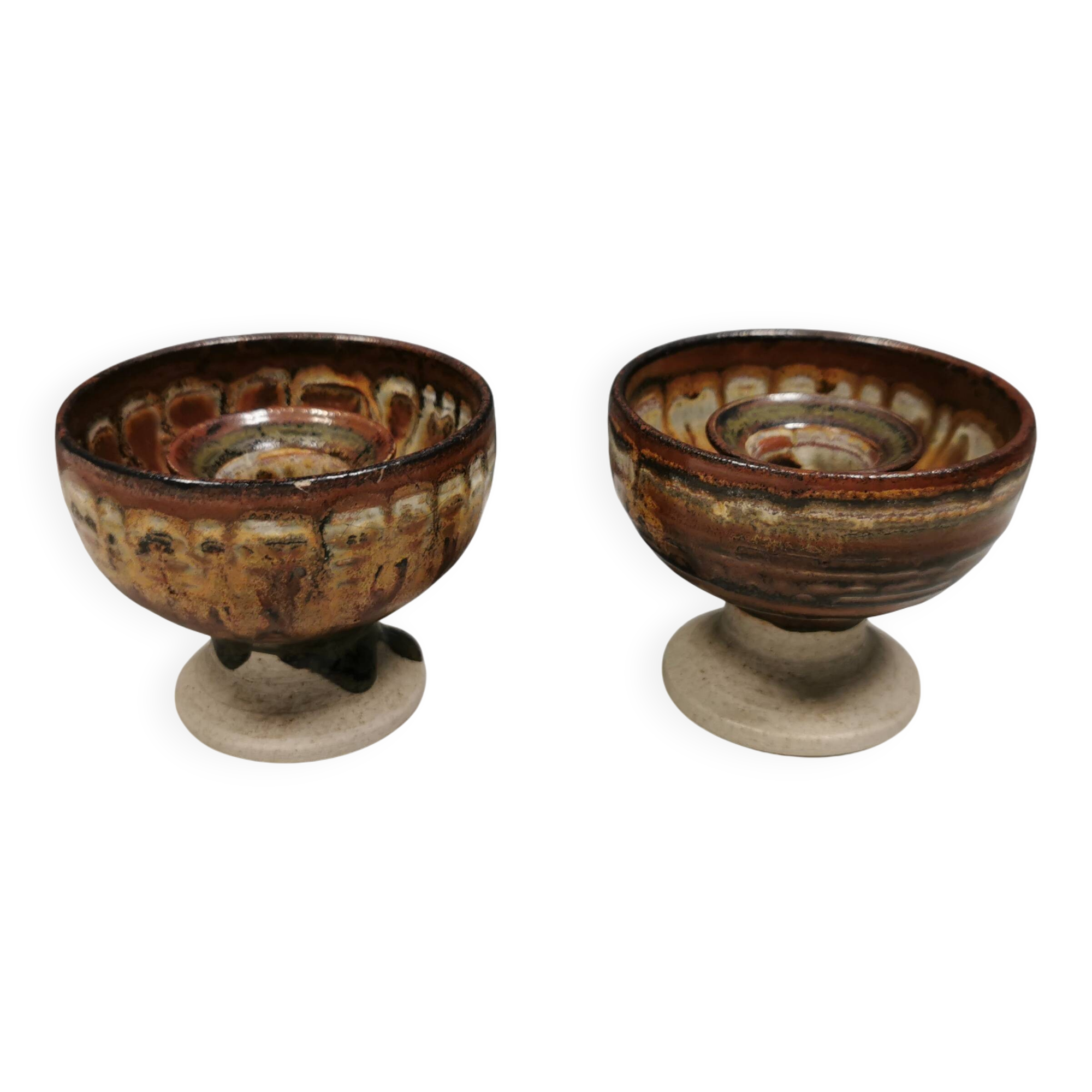 A set of ceramic candle holders in earthy colours.