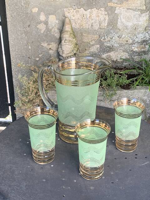 Serve an orangeade, a carafe and 3 glasses in green granite with golden trim.