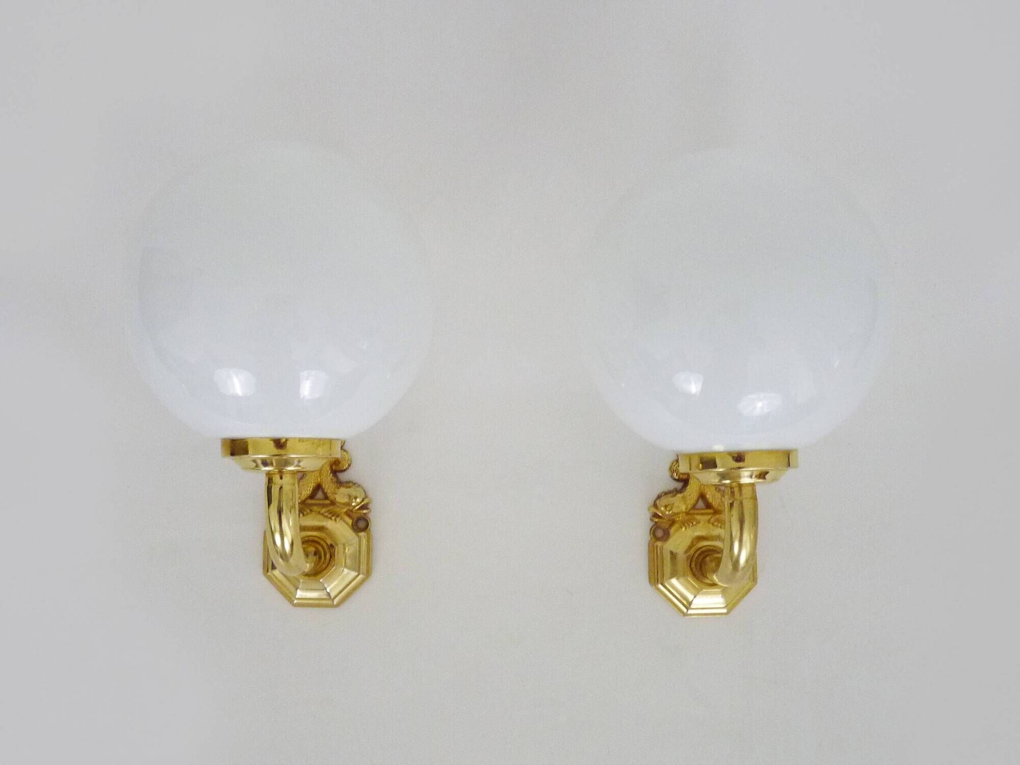 Pair of wall sconces with carp fish, brass and opaline globe.