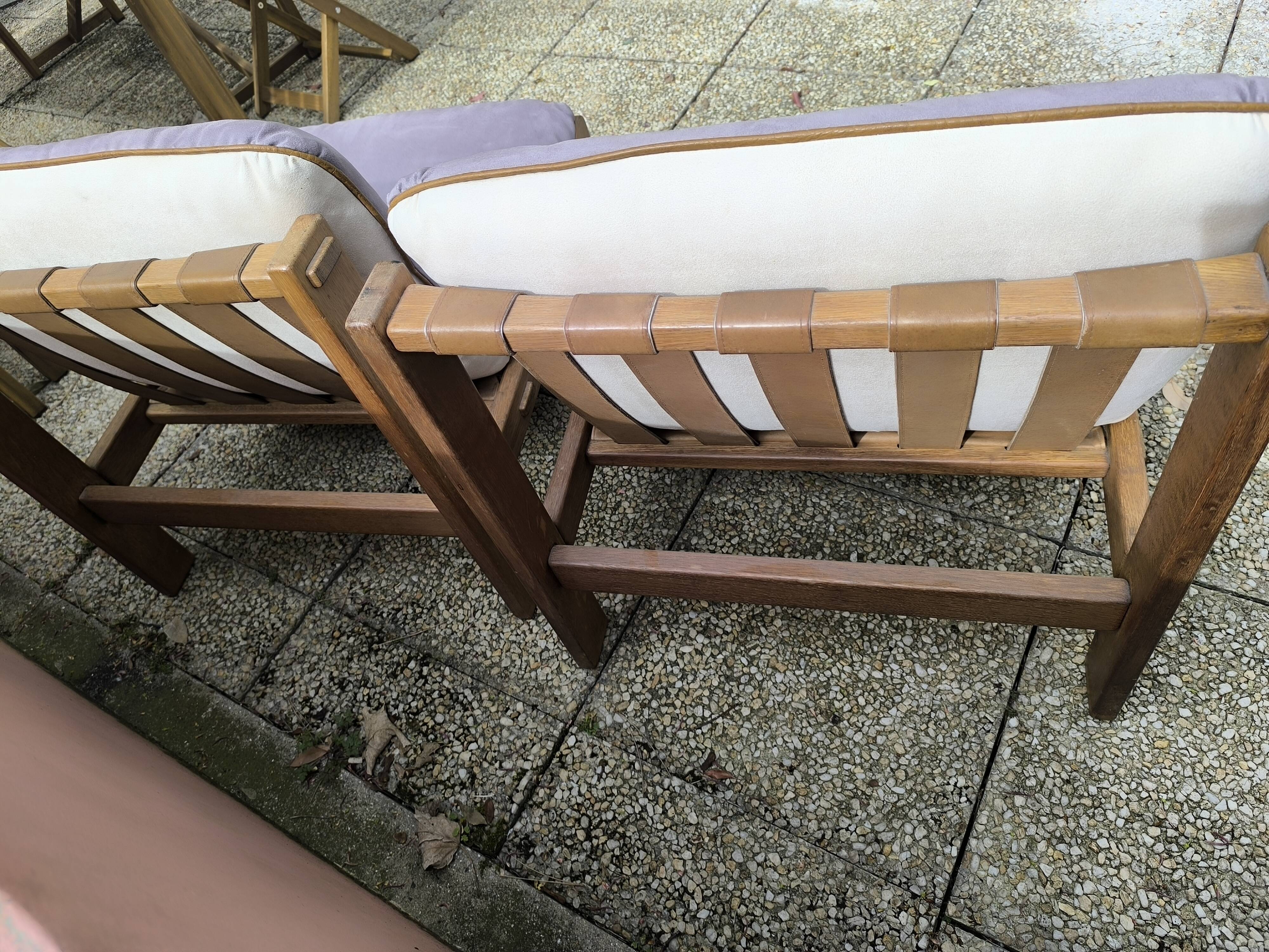 Pair of solid wood and leather lounge chairs, European work, circa 1970.