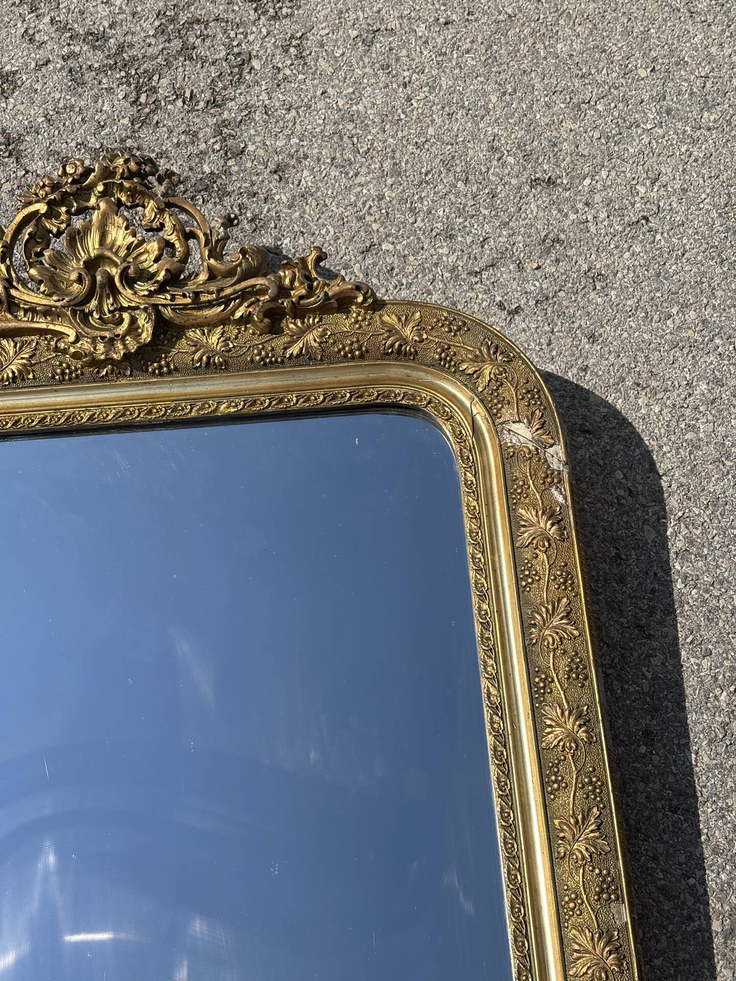 Golden mirror with a pediment from the early 20th century.