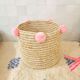 Moroccan basket with pale pink pompoms made of palm fiber