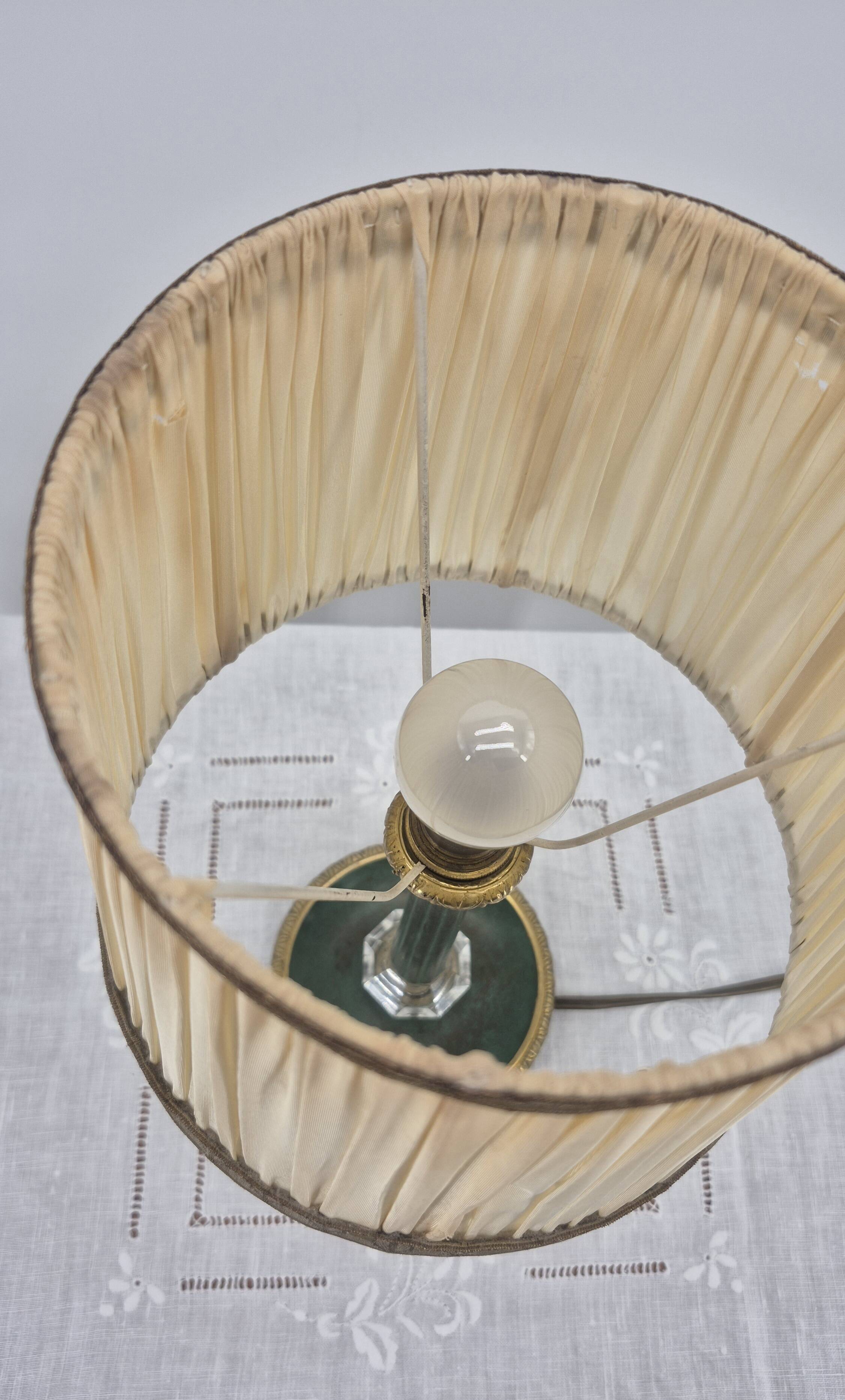 Brass table lamp with green patina and empire-style fabric shade.