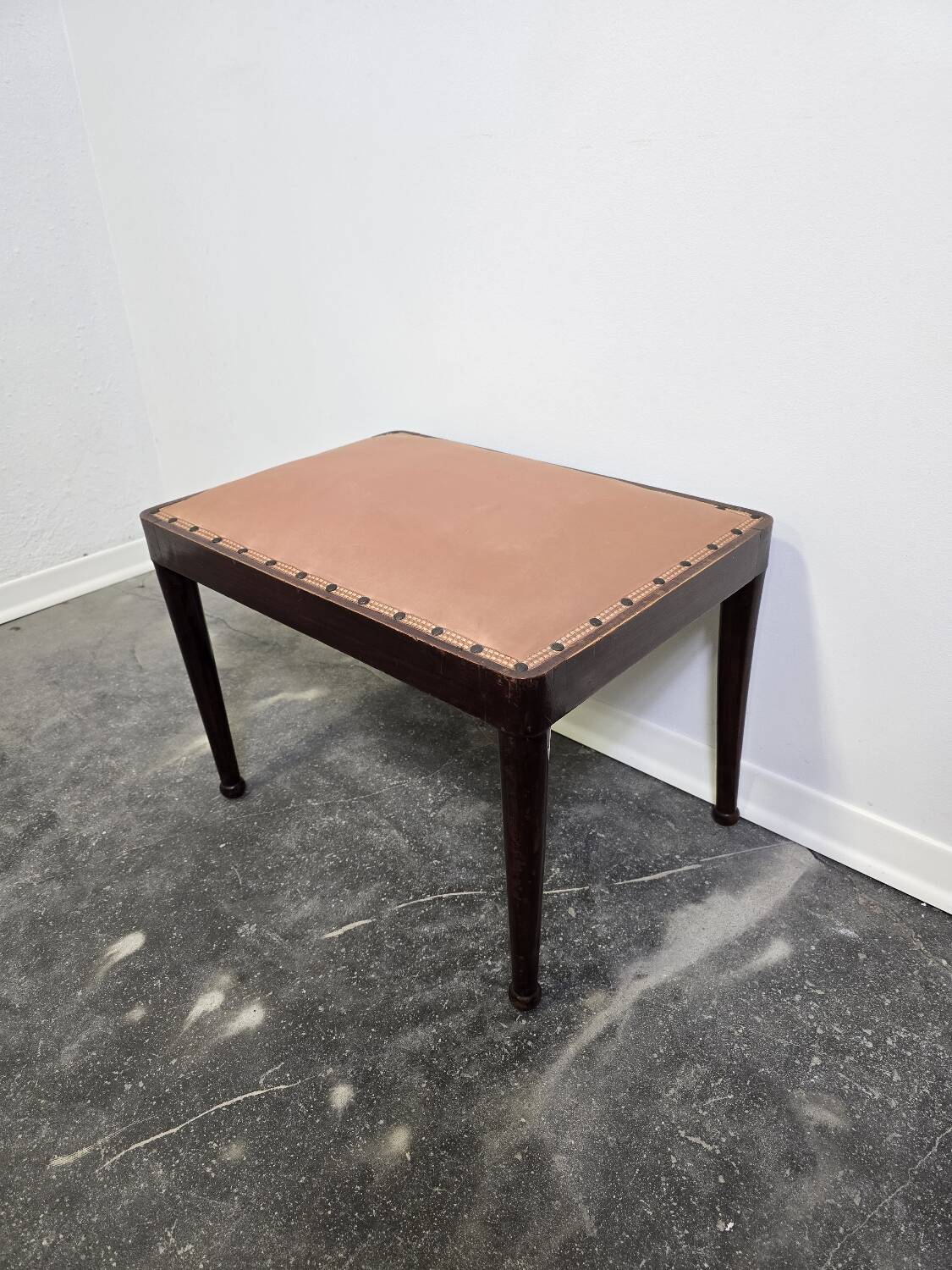 Vintage wooden ottoman from the 1940s with a silk top and studded trim.