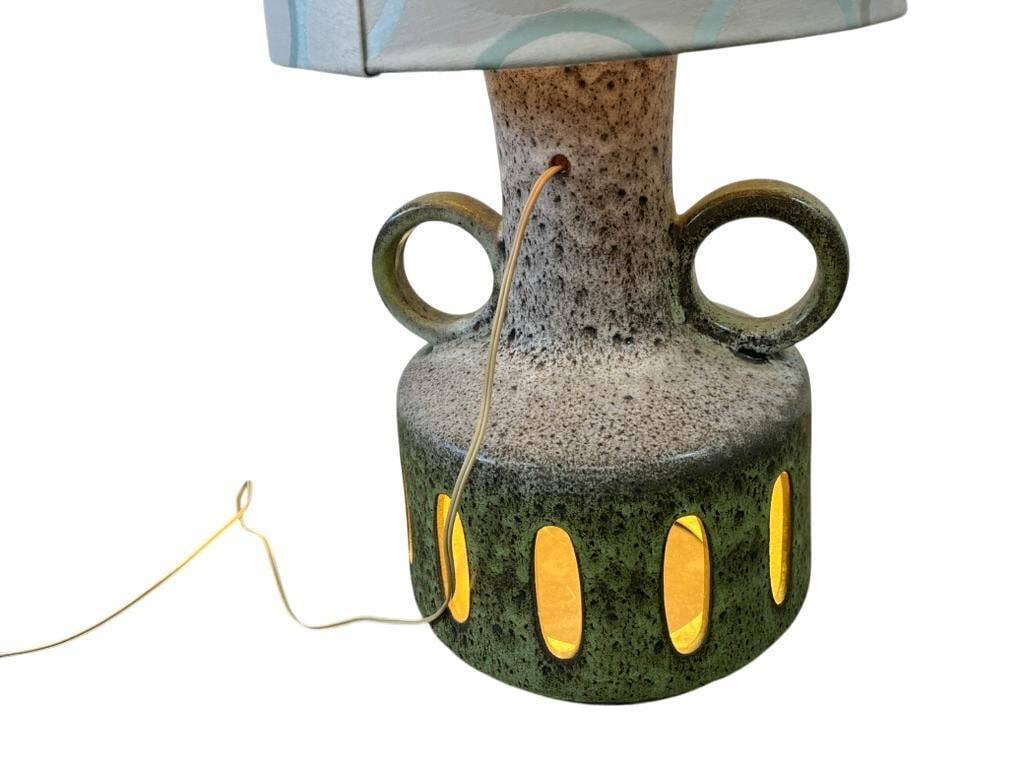 Vintage ceramic floor lamp with illuminated base.