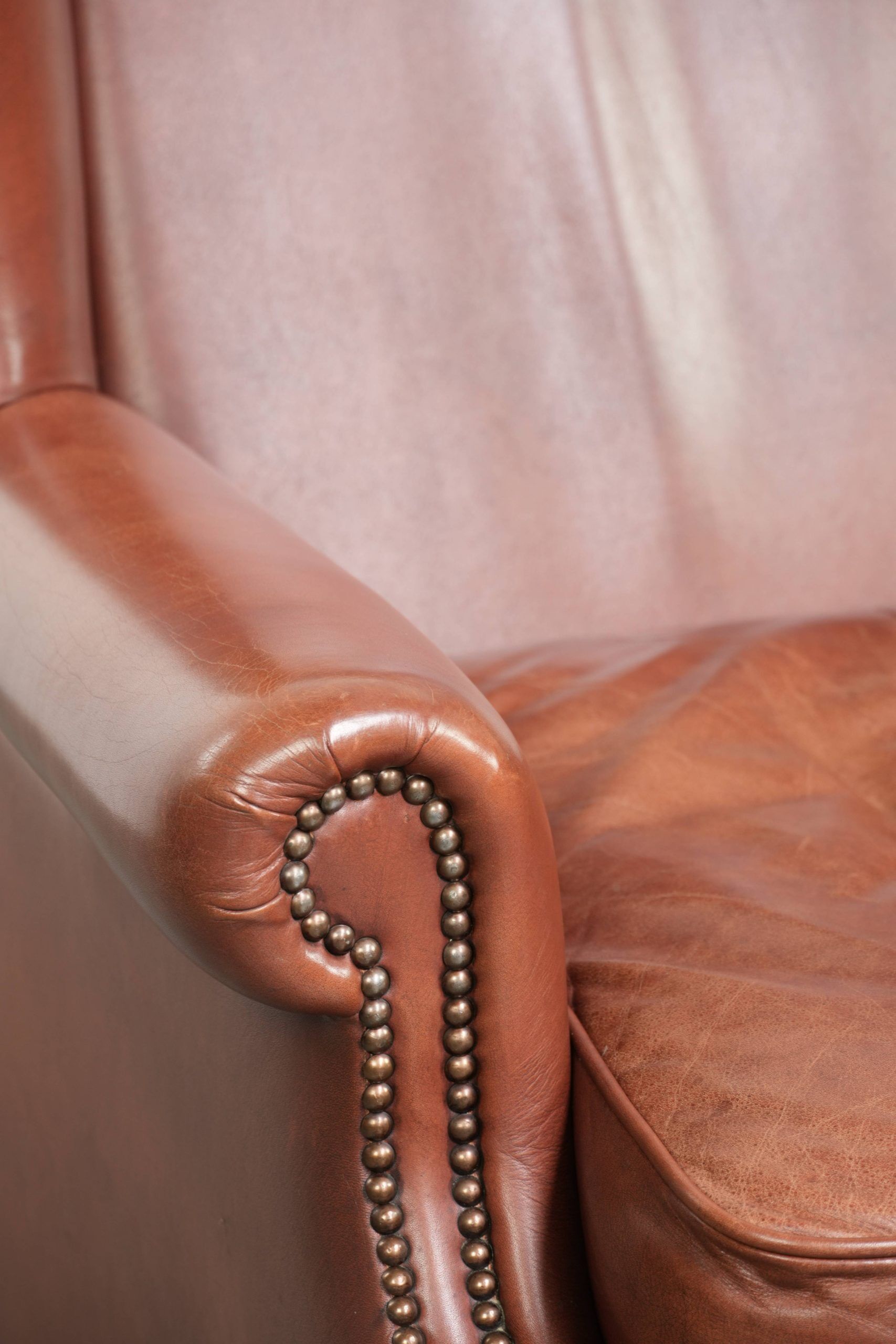 Cognac-coloured cow leather wingback armchair in English style