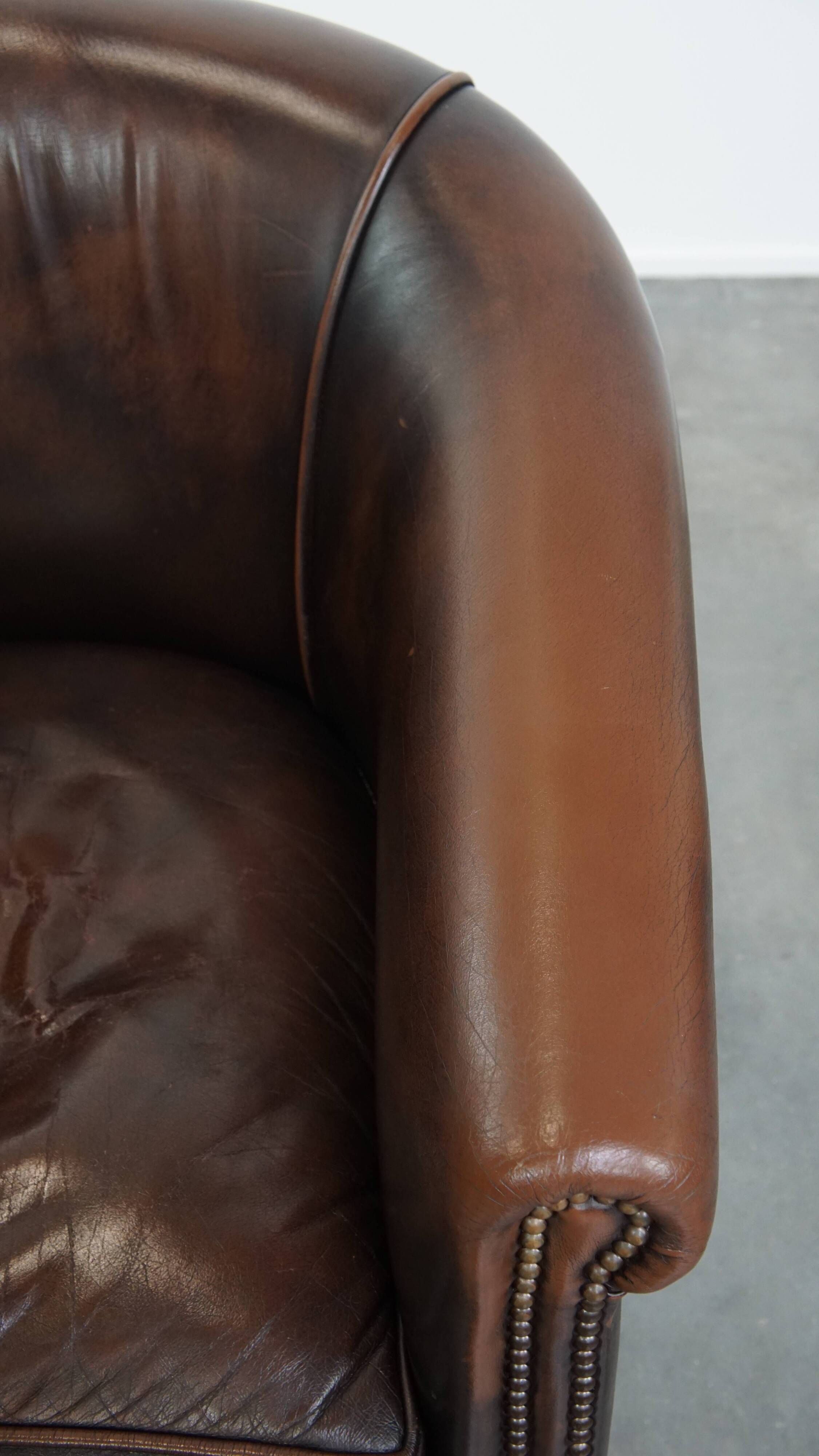 Fauteuil club de couleur foncée en cuir de vachette