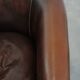 Fauteuil club de couleur foncée en cuir de vachette